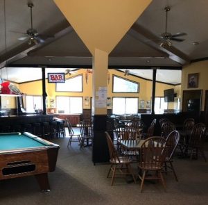 Inside bar with yellow walls pool table and table and chairs